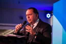 Hombre sobre escenario de Asociación Argentina de Productores Asesores de Seguros