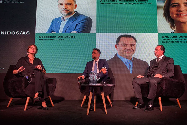 Hombre sobre escenario de Asociación Argentina de Productores sentados sobre el escenario Asesores de Seguros