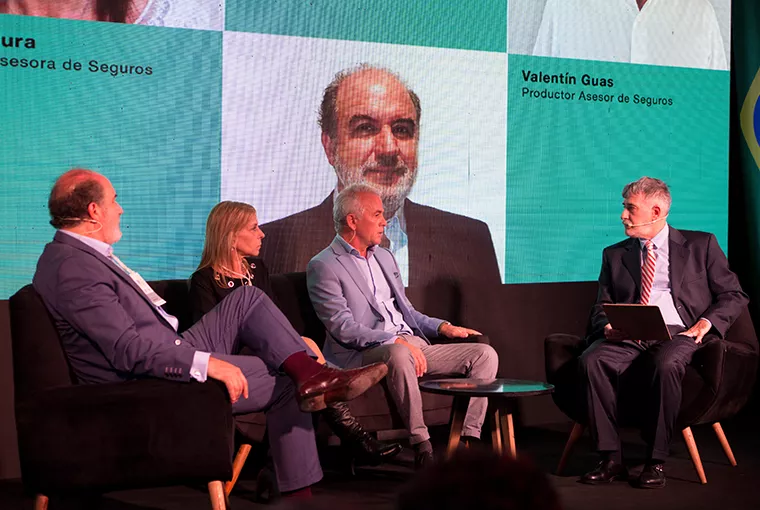 Hombre sobre escenario de Asociación Argentina de Productores sentados sobre el escenario Asesores de Seguros