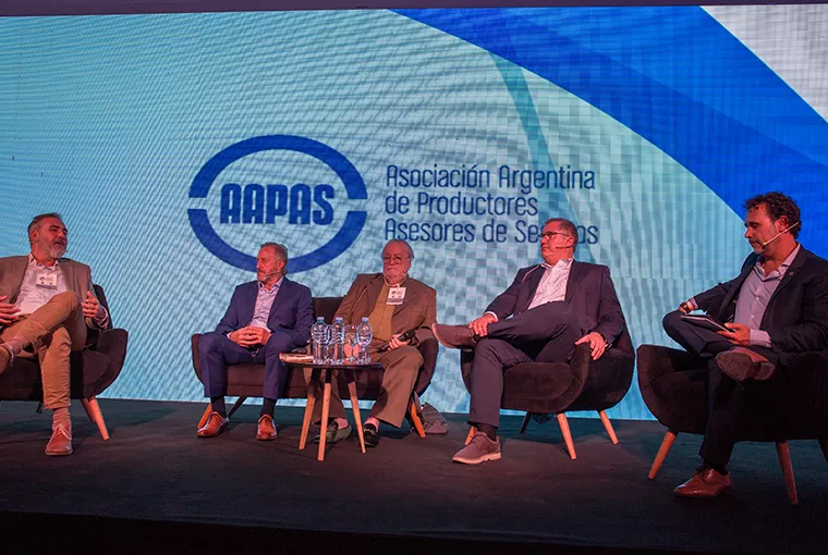 Hombre sobre escenario de Asociación Argentina de Productores sentados sobre el escenario Asesores de Seguros
