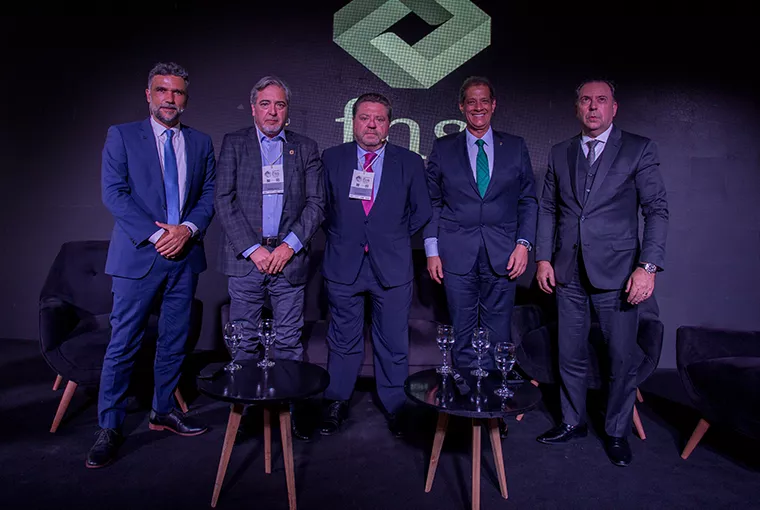Hombre sobre escenario de Asociación Argentina de Productores sentados sobre el escenario Asesores de Seguros