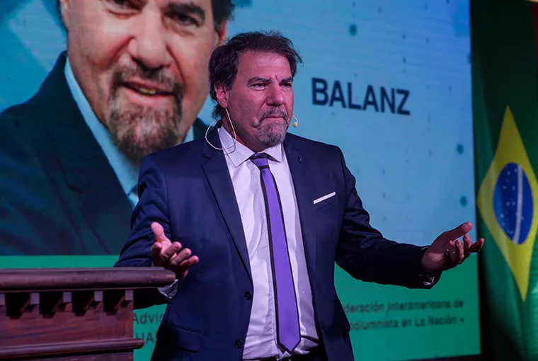 Hombre sobre escenario de Asociación Argentina de Productores sentados sobre el escenario Asesores de Seguros
