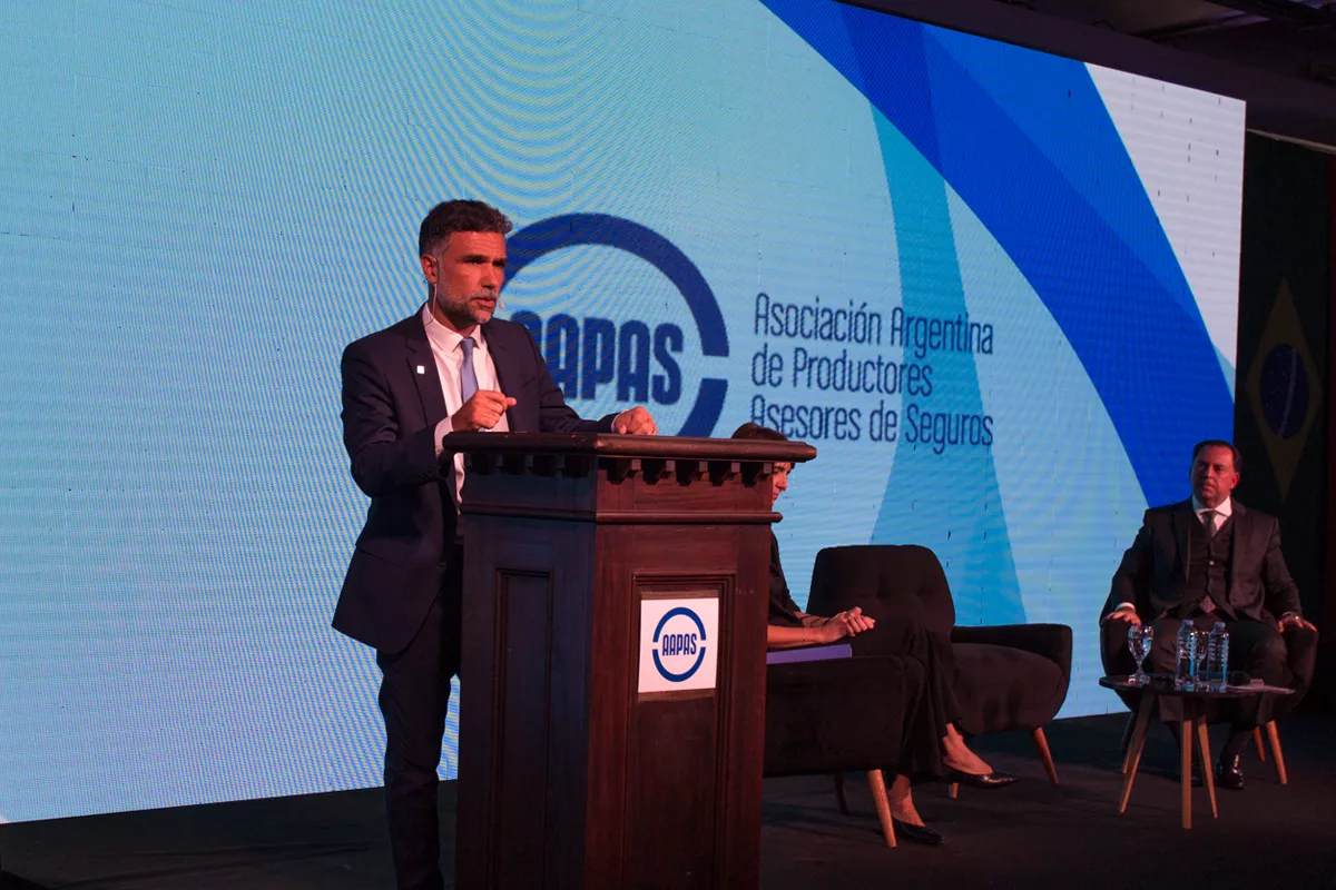 Hombre en escenario de AAPAS dando una conferencia sobre un atril